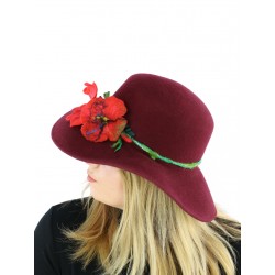 A maroon felt hat with a wide brim, decorated with a sprig of flowers