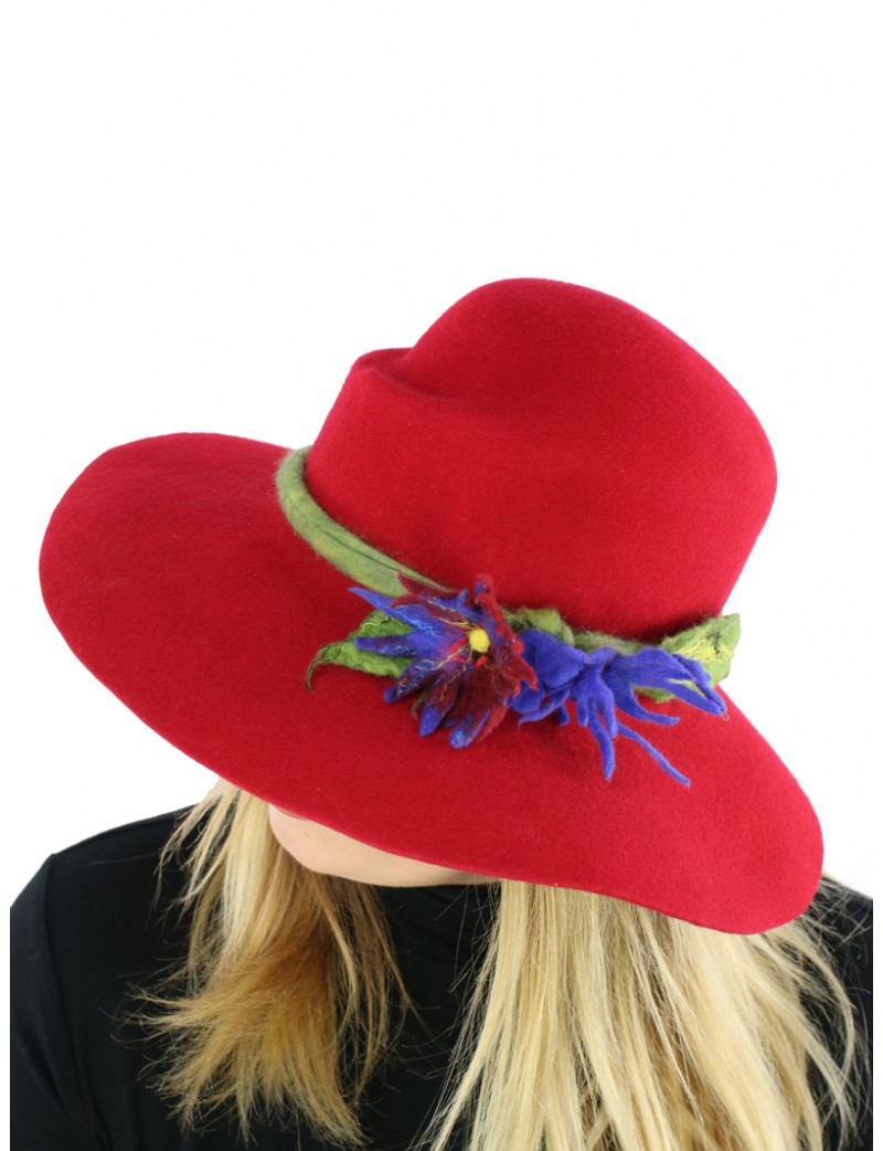 A red wide-brimmed felt hat decorated with a sprig of flowers