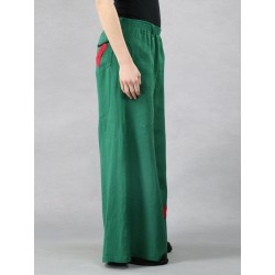 Green linen trousers with wide Swedish legs, decorated with sewn flowers.