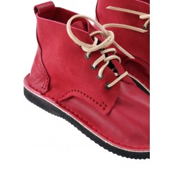 Ręcznie szyte wyższe buty skórzane w kolorze czerwonym, sznurowane rzemykami.