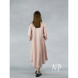 In powder pink, a dress with a longer back, decorated with black stitching