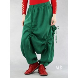 Green linen pants with a lowered crotch, finished with a belt on an elastic band, decorated with strings
