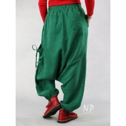 Green linen pants with a lowered crotch, finished with a belt on an elastic band, decorated with strings