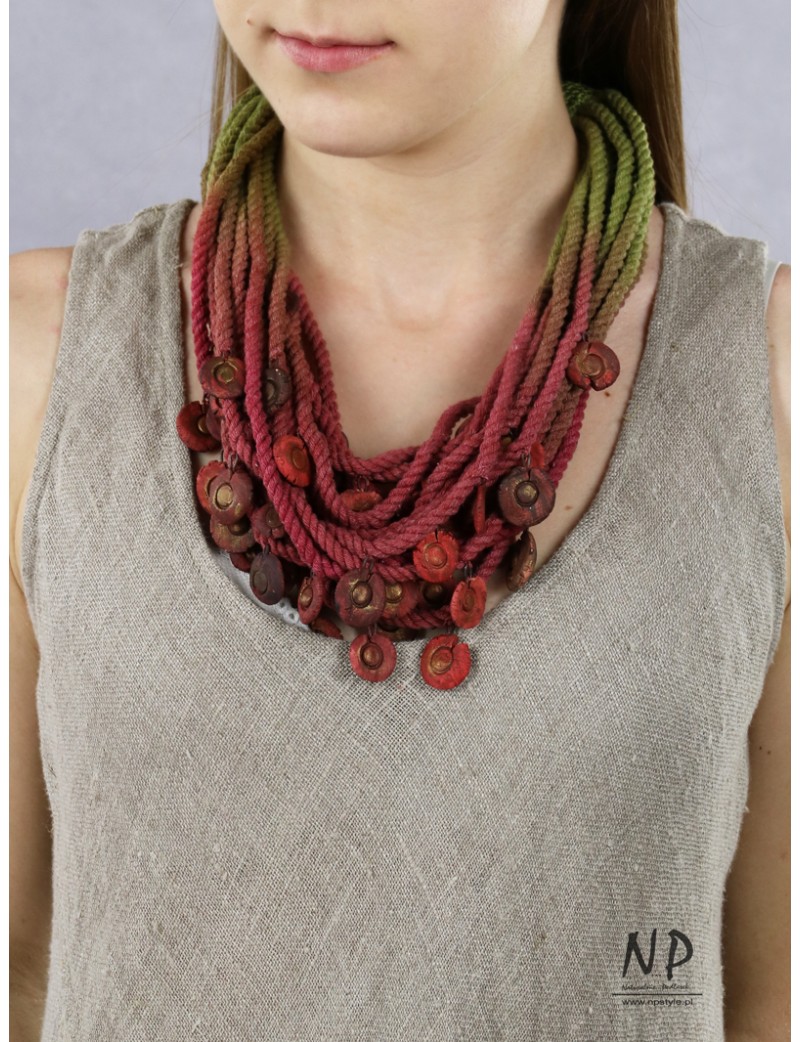 In shades of green, claret and dirty pink, a handmade necklace made of cotton string and ceramic ornaments