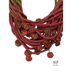 In shades of green, claret and dirty pink, a handmade necklace made of cotton string and ceramic ornaments