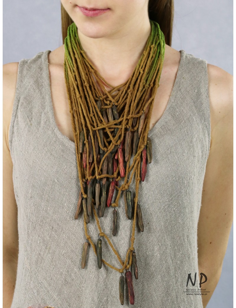 In the colors of green and honey, a handmade necklace made of cotton strings and ceramic ornaments