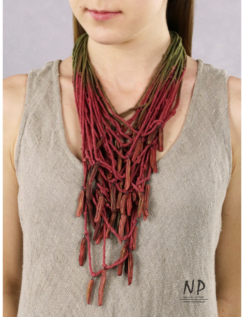 In the colors of dark pink and green, a handmade necklace made of cotton strings and ceramic ornaments