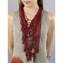 In dark pink and burgundy colors, a handmade necklace made of cotton strings and ceramic ornaments