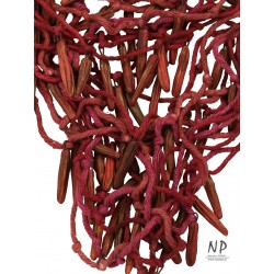 In dark pink and burgundy colors, a handmade necklace made of cotton strings and ceramic ornaments