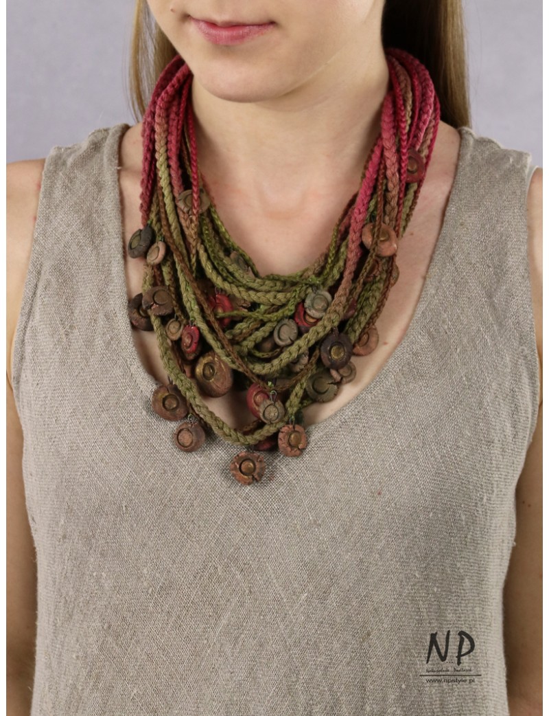 In the colors of green and dark pink, a handmade necklace made of cotton strings and ceramic beads