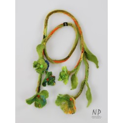 Długi naszyjnik z filcu wykonany w formie gałązki z zielonymi kwiatami oraz dołączoną broszką