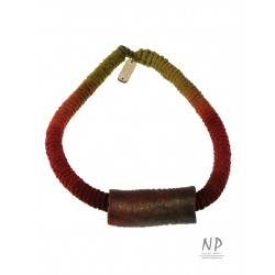 A handmade string necklace with a ceramic tube