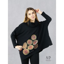 Czarna damska bluzka oversize z asymetrycznym dołem, ozdobiona ręcznie malowanymi wzorami.