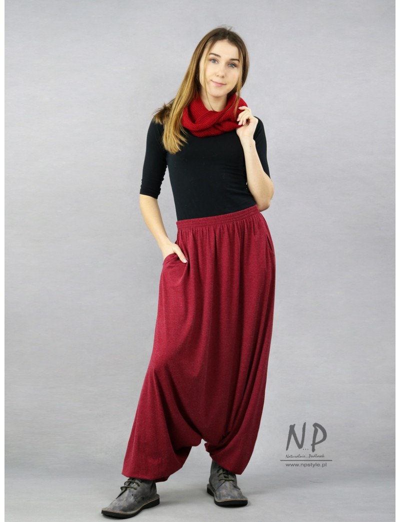 Maroon Aladdin pants with a low crotch, pockets and a belt on an elastic band