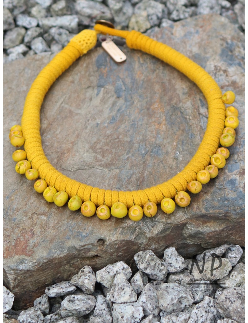Yellow women's necklace made of dyed cotton string and decorated with hand-made ceramics