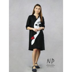 Black linen dress with a sleeve by the elbow, decorated with a sewn-on face