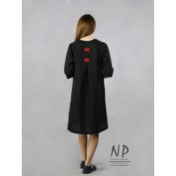 Black linen dress with a sleeve by the elbow, decorated with a sewn-on face