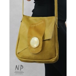 A hand-sewn women's handbag made of natural leather with a decorative flap
