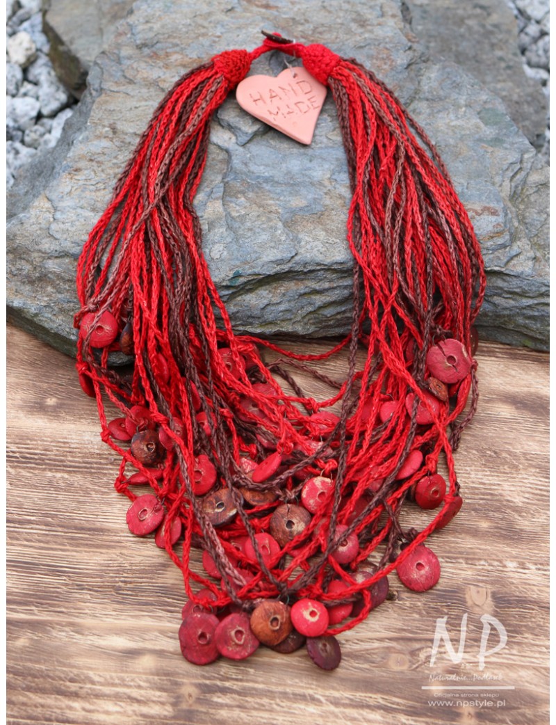 Czerwony naszyjnik wykonany z lnianych nici, ozdobiony ceramicznymi koralikami