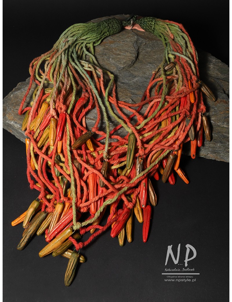 In the colors of green, red and orange, a handmade necklace made of cotton strings and ceramics