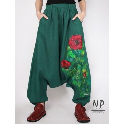 Green linen trousers with a dropped crotch decorated with hand-painted patterns