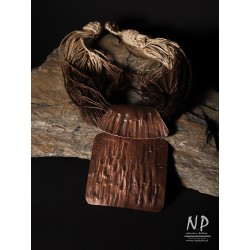 Handmade necklace made of linen strings decorated with a pendant made of copper