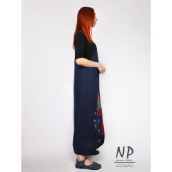 A long dungaree dress made of natural linen, decorated with hand-painted patterns