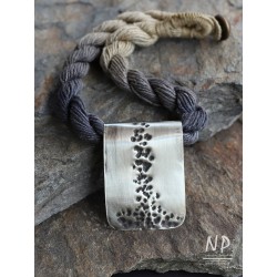 Necklace made of linen strings decorated with an original pendant made of New silver