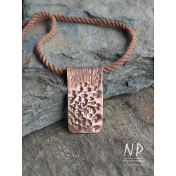 Handmade string necklace decorated with a pendant made of copper