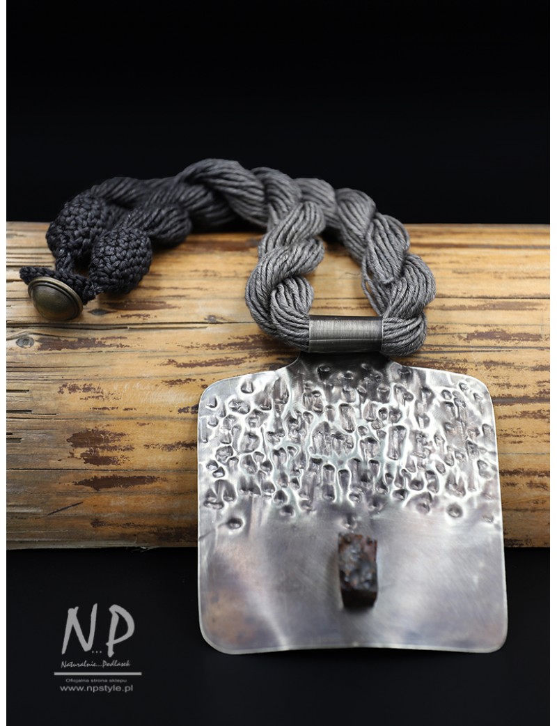 Necklace made of linen strings decorated with an original pendant made of New silver