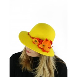 A felt hat with a large yellow brim, decorated with felted flowers.