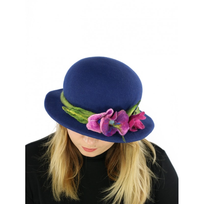 A navy blue felt hat with a small brim, decorated with a sprig of flowers