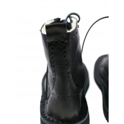 Black, hand-sewn leather boots laced with a thong.